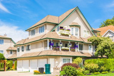 Three storey luxury residential house with four garage doors clipart