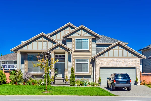 一个完美的邻居 全新的住宅 汽车停放在前面的车道上 有双层车库门和蓝天背景的大家族房子 加拿大不列颠哥伦比亚省 — 图库照片