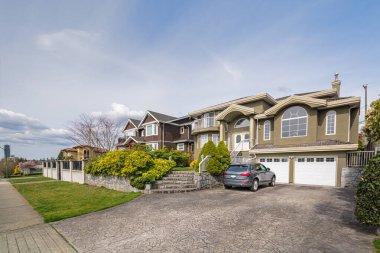 Vancouver, Kanada 'da bulutlu bir günde önünde bir araba park edilmiş lüks konutlar.