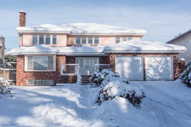 Big residential house in snow on winter season in Canada clipart