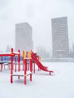 Çocuklar arka planda yüksek binalar olan karların üzerinde oynuyorlar. British Columbia, Kanada 'da kış mevsimi.