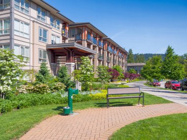 Vancouver, Kanada 'da aydınlık ve güneşli bir günde modern apartman boyunca yürüme yolu.