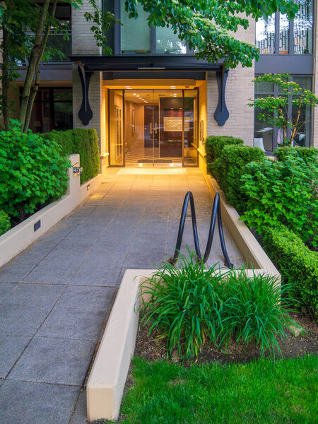 Residential building entrance with bike rack in front.