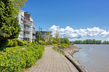 Waterfront walkway along the bank of Fraser river in New Westminster, British Columbia, Canada clipart