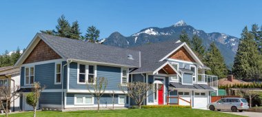 Mükemmel bir mahalle. Dağların tepesindeki karlı arka planda yeni lüks bir ev..