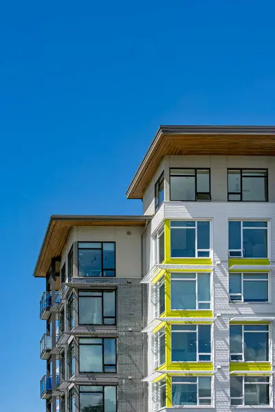 stock image Corners of brand new residential building on blue sky background.