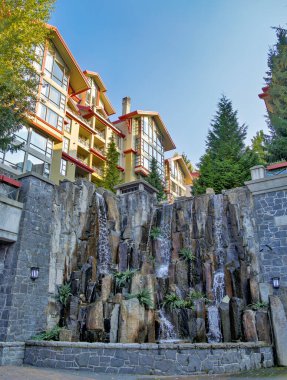 Whistler, British Columbia 'da günbatımında dekoratif şelaleli bir apartman bloğu.