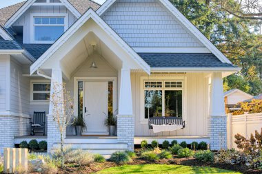 Verandanın altında verandası açık bir ev. Güneşli bir sonbahar gününde müstakil bir ev.