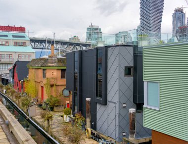 Row of housees on the water with view at downtown of Vancouver, Canada. clipart