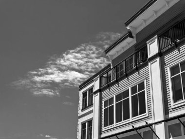 Güneşli bir günde bulutlu gökyüzü arka planındaki konut binasının tepesi.