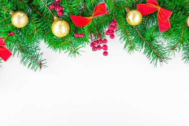 Noel ağacı dalları ve Noel süslemeleri olan beyaz bir arka plan. Noel tebrik kartı için güzel bir arka plan.