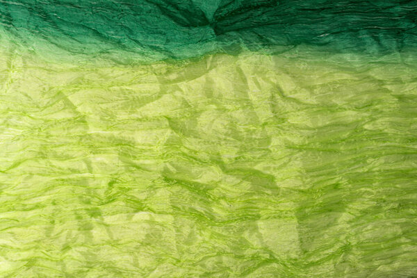 Green wrinkled fabric background.