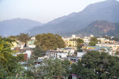 Rishikesh, Hindistan 6 Aralık 2024: Rishikesh kasabası Himalaya Shivalik aralığı ile sıcak sarı güneş ışığıyla yıkandı.