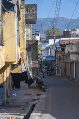 Rishikesh, Hindistan, 06 Aralık 2024: Ganj Nehri 'nin sakin kıyıları yakınlarındaki Rishikesh' teki pazar alanına giden yoğun bir yol.