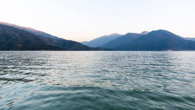 Derin su gölde akar, üzerinde mavi dağlar yüksekte durur. Güneşli dağ tepeleri Tahri Gölü 'nün görkemli manzarasını güzelleştirir..