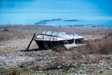 Terk edilmiş eski bir sürat teknesi Tahri Gölü 'nün kenarlarında dinleniyor, zamanın nasıl geçtiğini ve ihmal edildiğini gösteriyor. Tekne manzaraya tarih katıyor..