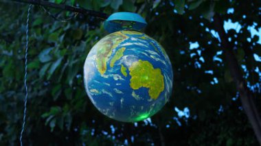 Dünya 'nın bir modeli, bir ağaç tarafından desteklenen ekseni üzerinde sürekli döner. Bu görüntü gezegenimizin güzelliğini ve dönüşünü vurguluyor..