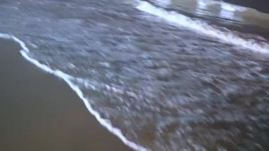 Gece vakti sahile vuran deniz dalgalarının huzurlu bir görüntüsünü sunar. Ritmik ses yakınındakileri rahatlatır..
