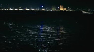Dalgalar, yanan binalar ve çarpan dalgalarla çevrili Mumbai Deniz Yolu 'nun yakınlarındaki bir teknenin denize açılmasının güzelliğini yansıtıyor..
