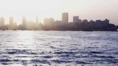 Denizin kıyısındaki limanlar ve ufuk çizgileri canlıdır ve pek çok tekne mevcuttur. Akşam günbatımında loş ışıklar yanar, atmosferi güçlendirir..