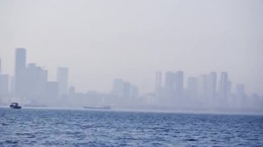 Gezinen bir tekneden akşam görüntüsü şehrin ufuk çizgisini ve kıyı şeridini gözler önüne seriyor..