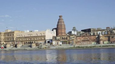 Vrindavan 'daki Yamuna Nehri' ndeki Keshi Ghat manzarası, birçok tapınak ve kenarda yürüyen insanları yansıtıyor, sudaki yansımalar manzaraya güzellik katıyor..