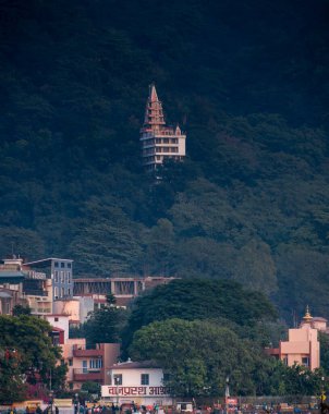 Rishikesh, Hindistan, 08 Aralık 2024: Vanprastha Ashram 'a ve Rishikesh' e yakın bir pazar alanına bakan derin dağlara kurulmuş bir tapınak. Mekan bir huzur hissi uyandırıyor..