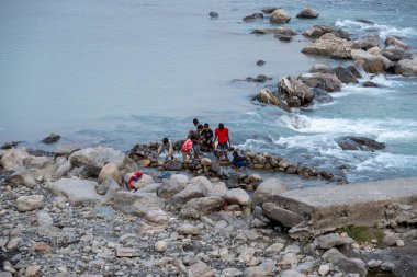 Rishikesh, Hindistan, 08 Aralık 2024: Çocuklar Rishikesh 'teki Ganj Nehri' nden bozuk para toplarken görülebilir. Eğlenceli sahne, yerel kültürü ve nehirle olan bağlantıyı yansıtıyor..