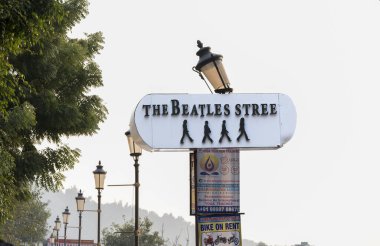 Rishikesh, Hindistan, 08 Aralık 2024: Rishikesh 'teki Beatles sokak tabelasına sütundaki diğer posterler eşlik ediyor. Bu alan ünlü grubun kültürel etkisini kutluyor..
