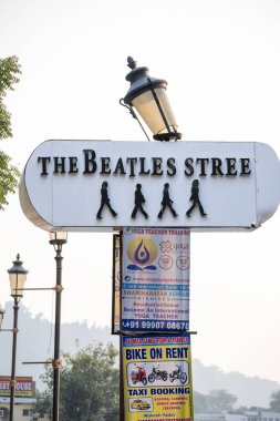 Rishikesh, Hindistan, 08 Aralık 2024: Beatles sokak tabelasının dikey bir görüntüsü Rishikesh 'te çeşitli posterler sergiliyor. Bu sanatsal görüntü bölgenin tarihini vurguluyor.
