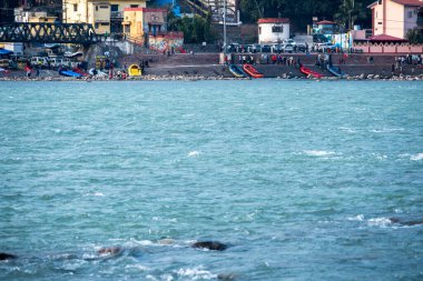Rishikesh, Hindistan, 08 Aralık 2024: Sallar ve insanlar Rishikesh kasabasında nehrin karşısında görüldü. Canlı ortam, bölgedeki popüler açık hava faaliyetlerini vurguluyor.