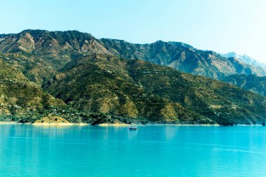 Gölde yüzen bir otel mavi ve yeşil sisle kaplanmış dağların çarpıcı manzarasını sunuyor. Bu büyüleyici ortam rahatlamak için mükemmel..
