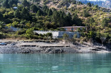 Gölde yer alan bir otel arkadaki yeşil dağların manzarasıyla övünür. Doğal manzara, hedefin genel cazibesini arttırır..