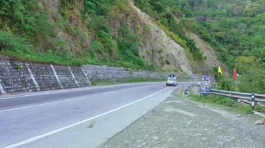 Rishikesh, Hindistan - 08 Ocak 2025: Himalaya yolunda iki araba kesişiyor, yeşil ağaçlarla çevrili. Sürücü, bölgenin manzaralı güzelliğini sergiliyor..