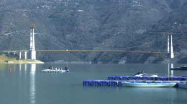 Rishikesh, Hindistan 24 Ocak 2025: Tehri Gölü 'nde yüzen bir platform, yakınlardaki bir köprüye götüren iki adam tarafından kürek çekiliyor..