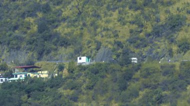 Rishikesh, Hindistan 24 Ocak 2025: Rishikesh 'in yukarısındaki dağ yolundan geçen bir minibüs çarpıcı manzaralar sunan manzaralı rotalarda yol alırken görüldü..