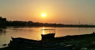 Mathura 'da güzel bir günbatımı, Yamuna Nehri' nin sularına yansıyor. Kenarlarında tekneler var. Resimli bir manzara yaratıyorlar..
