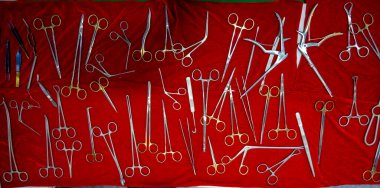 Üst görünümde cerrahi operasyonlar ve tıbbi prosedürler için uygun bir makas ve cımbız dizisi gösterilir.