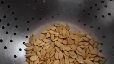 Tepsiye yerleştirilmiş sarı karpuz tohumlarını yakalıyor, canlı renklerini sergiliyor..