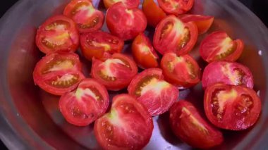 Tepeden çekimde taze kesilmiş kırmızı domatesler bir tepside sergileniyor, canlı renkleri vurgulanıyor..