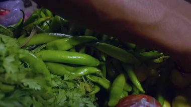 Taze yeşil biberler diğer sebzelerin yanında satışta, renkli müşterileri cezbediyor..