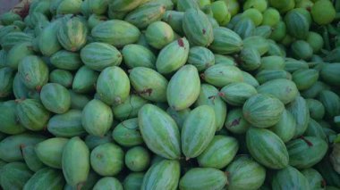 Bir parval ya da sivri su kabağı yığını satılığa çıkarılabilir ve kamera sağdan sola hareket ederek erişilebilirliğini gösterir.