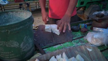 Bir sokak satıcısı, Katahal olarak da bilinen Jackfruit 'i uzun bir bıçakla kesiyor ve satışa hazırlıyor..