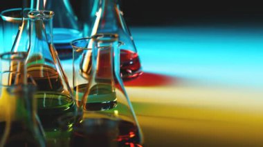 Laboratuvar vitrinlerinin kusursuz döngüsü renkli sıvılarla doludur. Cam şişelerden, şişelerden ve yakıcı etkisi olan sıvılardan çok renkli ışık geçiyor. Bilim kavramı, laboratuvar