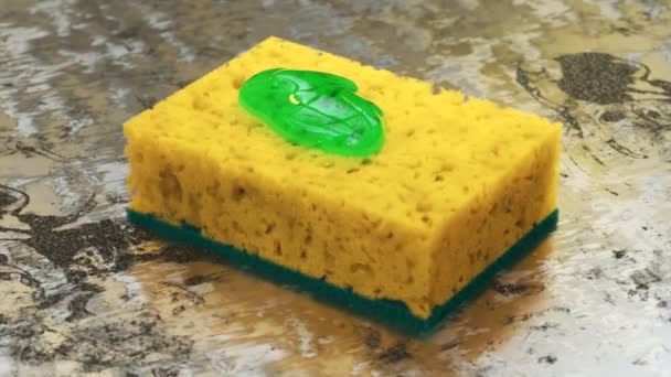 在一个生锈的金属厨房表面的黄色海绵上挤进了一小滴绿色的肥皂 将洗碗液洗涤剂倒在洗碗盘上 用干净的宏射法洗净 — 图库视频影像