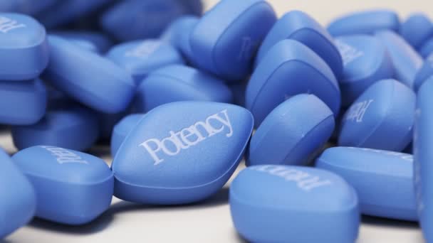 青い丸薬の山と 明るい背景に満ちた瓶 インポテンスのための現代的かつ効果的な治療法 高齢者の性行為の象徴 カメラトラックバックとヘッディング — ストック動画