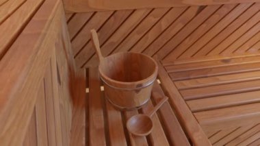 Boş saunanın içinde geleneksel sauna aksesuarları. Ahşap Finlandiya saunası, rahatlama ve temizlik için spa odası. Su kovası ve kepçeli rahat ahşap oda..