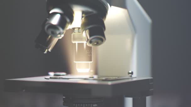Moderni Mikroskooppi Seisoo Sumuisessa Oikukkaassa Laboratoriossa Valosäteet Virtaavat Tiheän Sumun — kuvapankkivideo