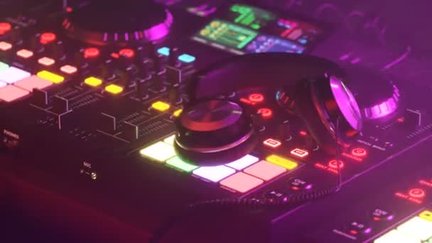 Dj配备专业的迪杰耳机 在浓雾俱乐部的氛围中 五彩缤纷的灯光闪烁 照亮当代硬件 派对期间的现代音乐娱乐技术 — 图库视频影像