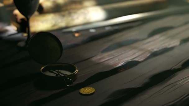 手绘的带有动画图画的古代地图在木制桌子上铺开 上面有指南针 剑和高脚杯 显示海盗船 棕榈树和装满黄金的宝箱的地图 冒险时间 — 图库视频影像